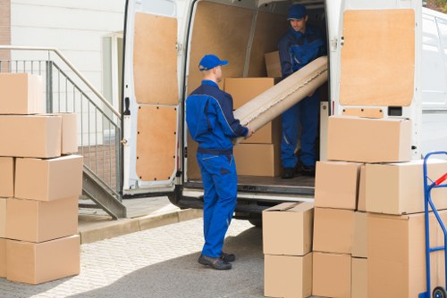 Storage site staff sorting recyclable cardboard and reusable packing materials